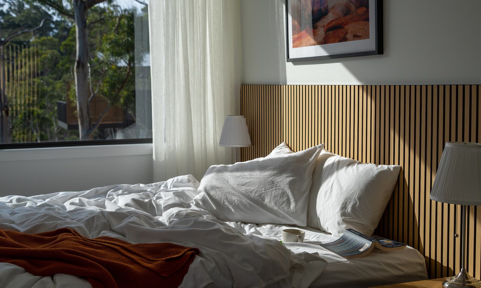 Comfortable bed overlooking outside forest view