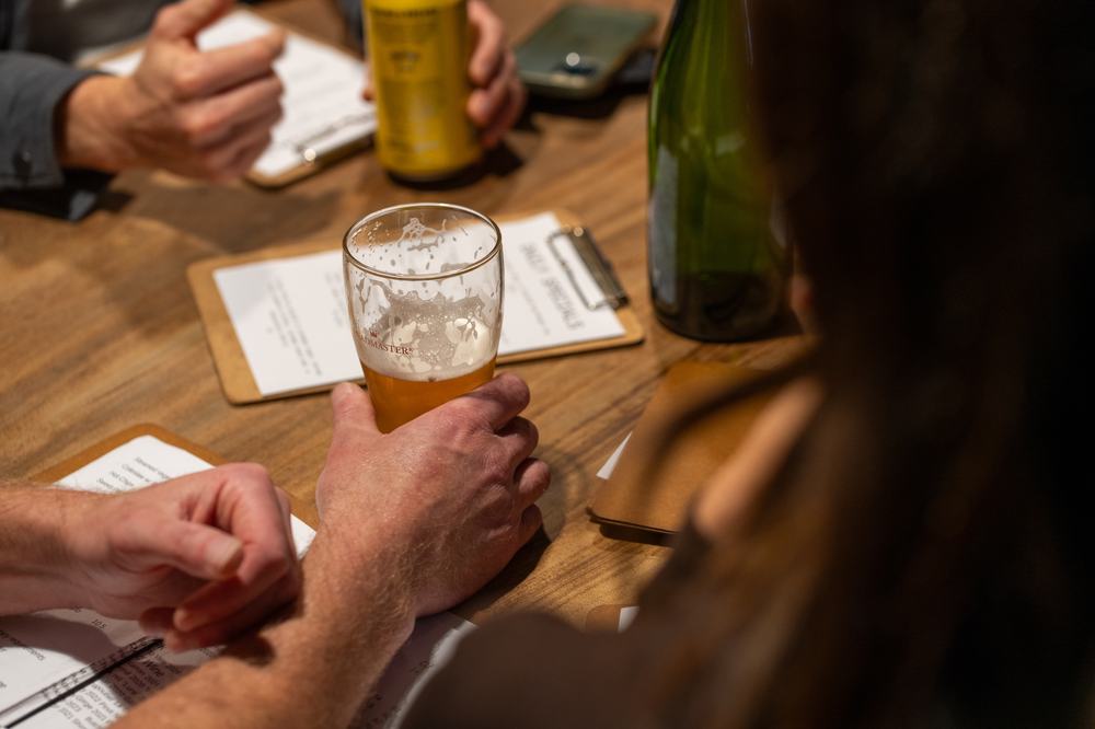 People sitting around table with drinks looking at menu